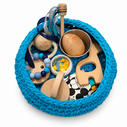 Detalle del contenido del cesto Caribbean Blue con palo de miel y cintas azules, huevo en la flanera y jirafa de madera.