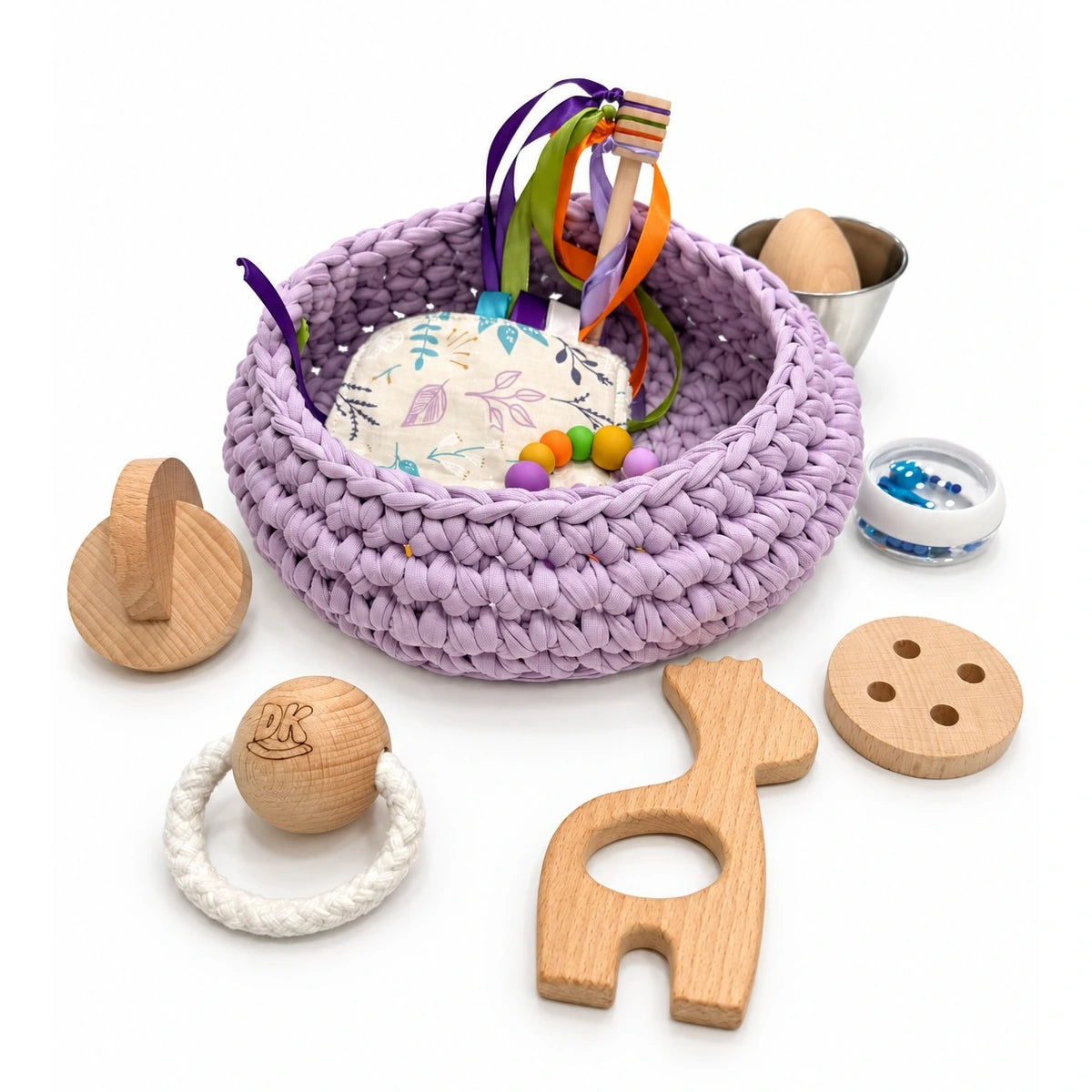 Cesto sensorial Lavender Mist con jirafa, discos entrelazados, botón y bola de madera alrededor.
