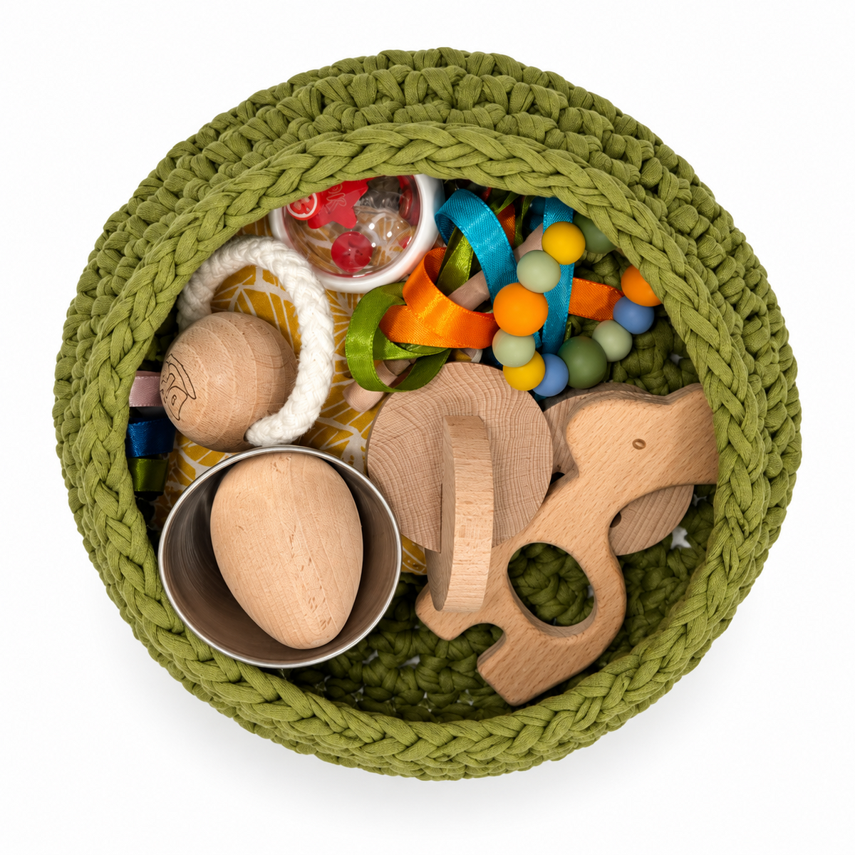 Vista cenital del cesto sensorial Olive Grove con jirafa, discos de madera, anilla de silicona y tarrito rojo.