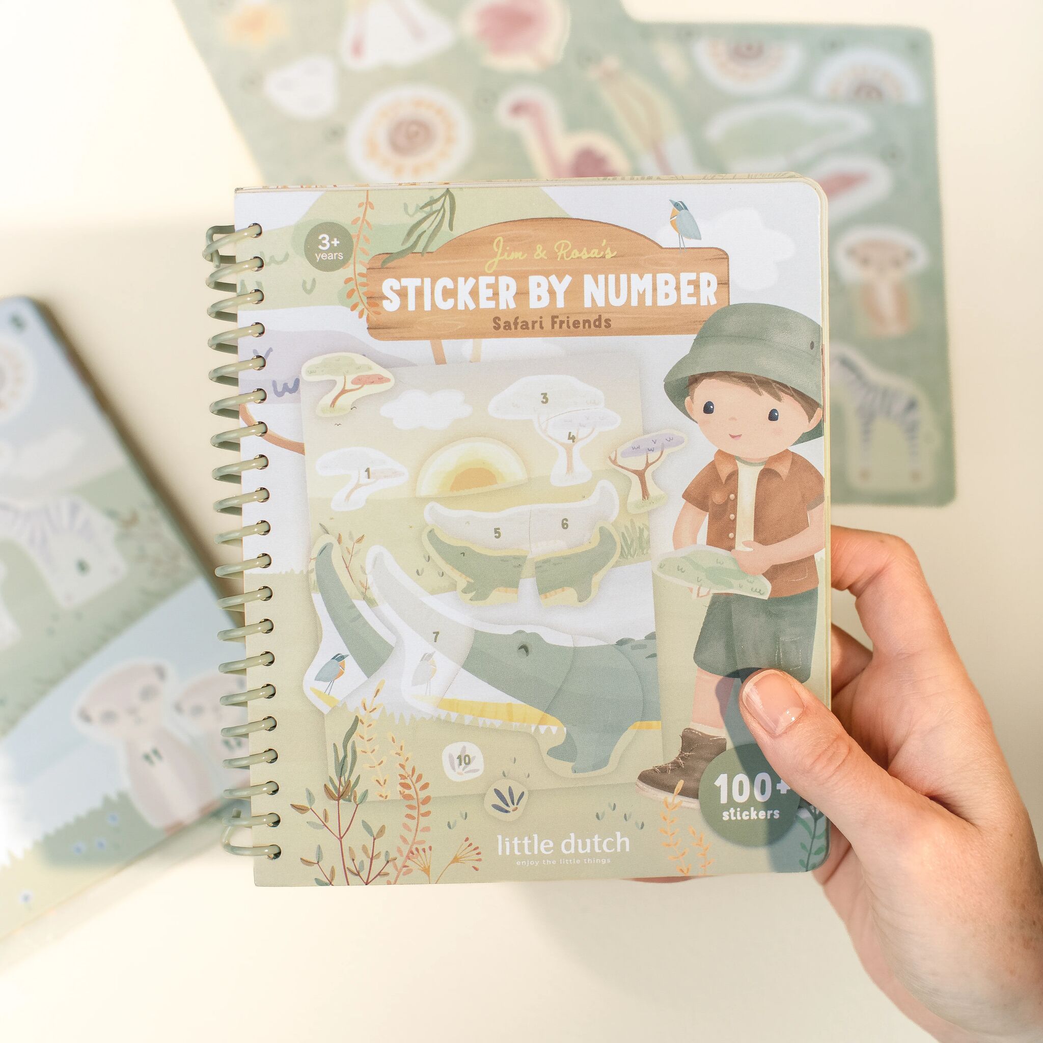 Libro de pegatinas Jim Safari Friends sostenido en una mano