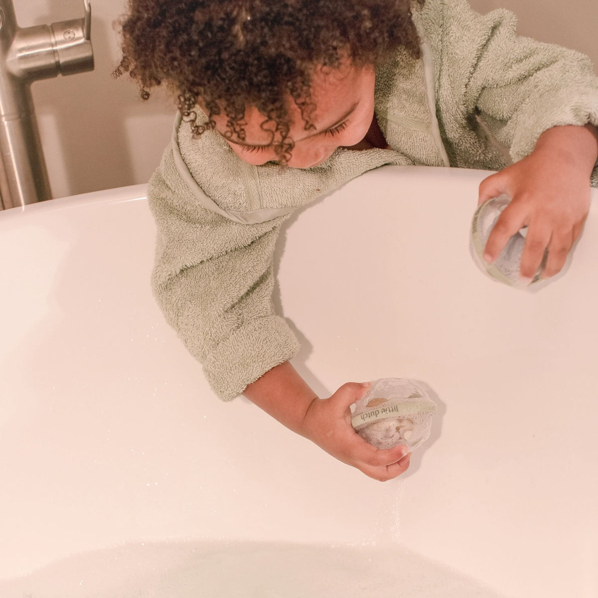 Niño moviendo las bolas de animales en el agua