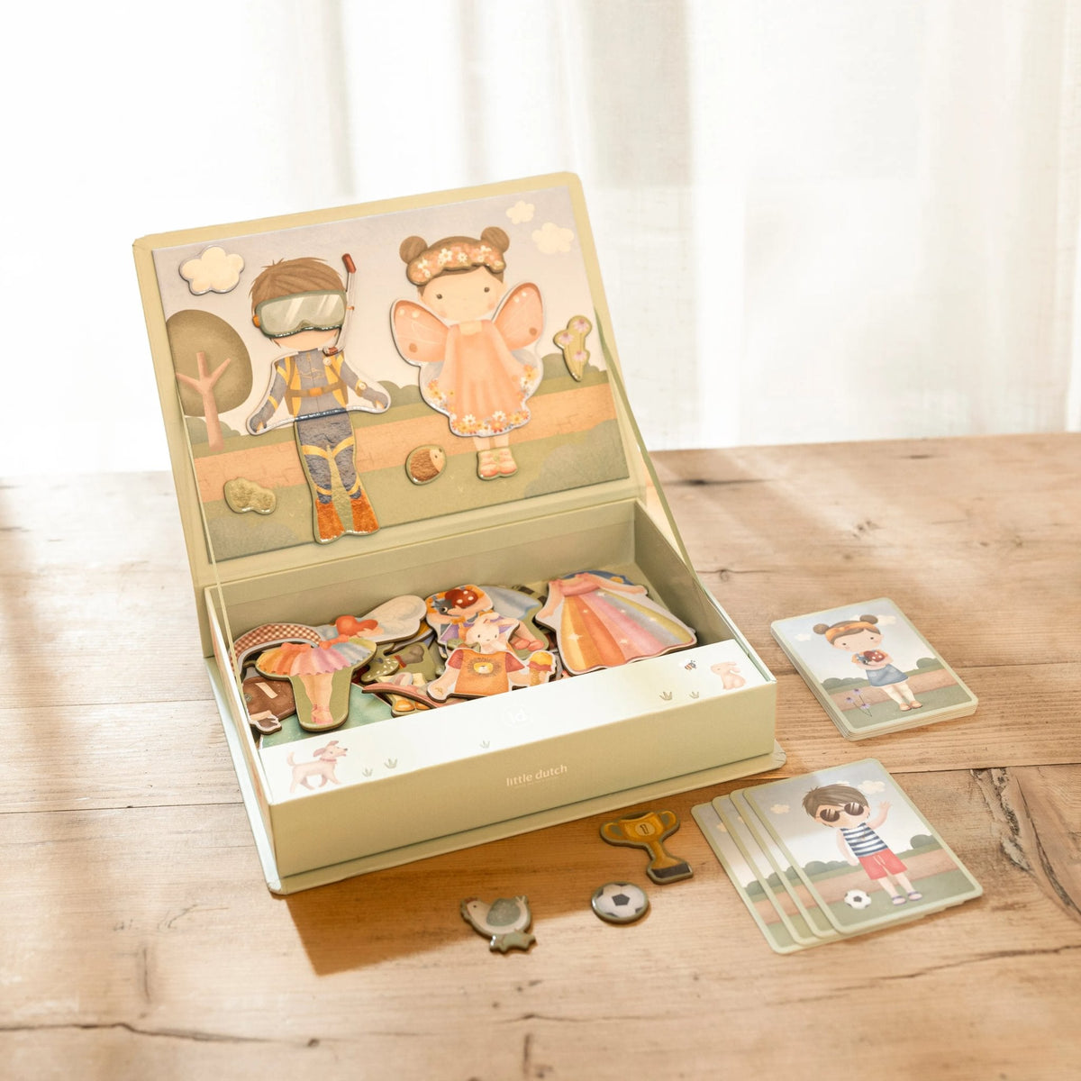 Caja del juego magnético Viste a Jim y Rosa sobre una mesa de madera