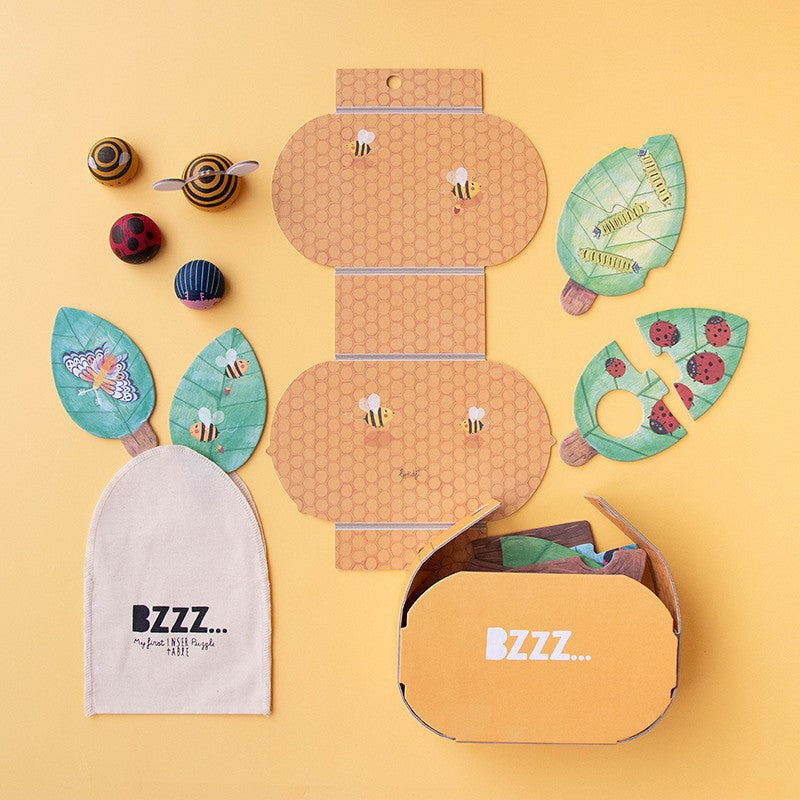 Contenido de Bzzz con caja, bolsa y figuras de madera