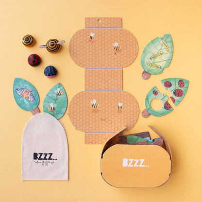 Contenido de Bzzz con caja, bolsa y figuras de madera
