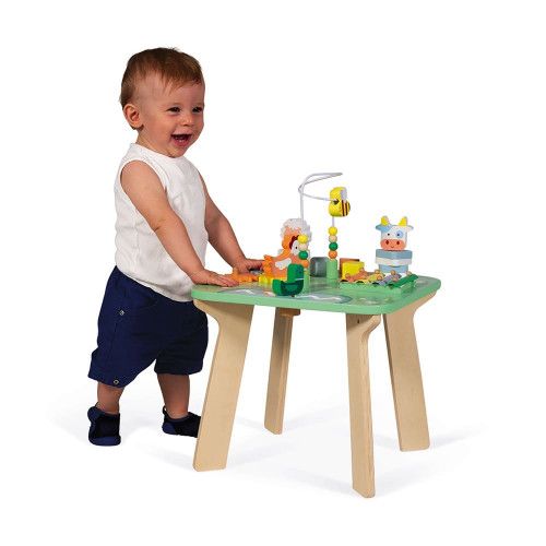Niño de pie junto a la mesa Bonita Pradera — Janod