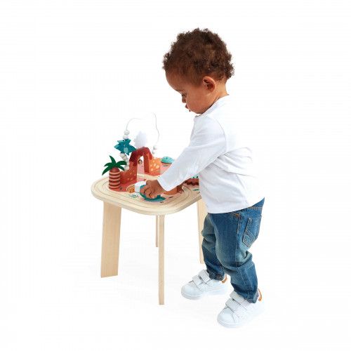 Niño de pie jugando con la mesa Dino — Janod