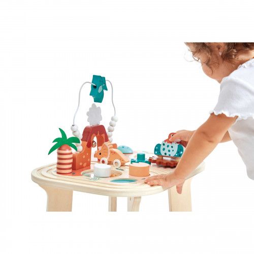Manos explorando las actividades de la mesa Dino — Janod