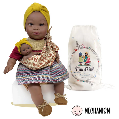 Muñeca Alika con bebé Burgundy junto a su bolsa de tela Nines d'Onil