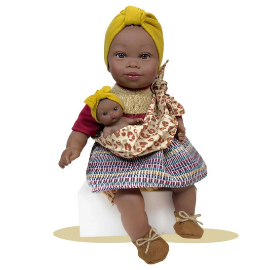 Muñeca Alika con bebé Burgundy de Nines d'Onil, con turbante amarillo y portabebés