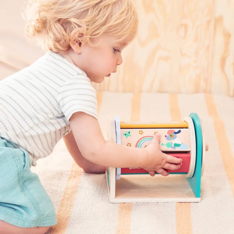 Bebé manipulando Tournicolor sentado en el suelo — Lilliputiens