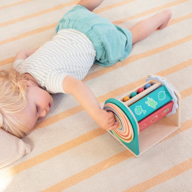 Bebé tumbado manipulando la espiral de Tournicolor — Lilliputiens